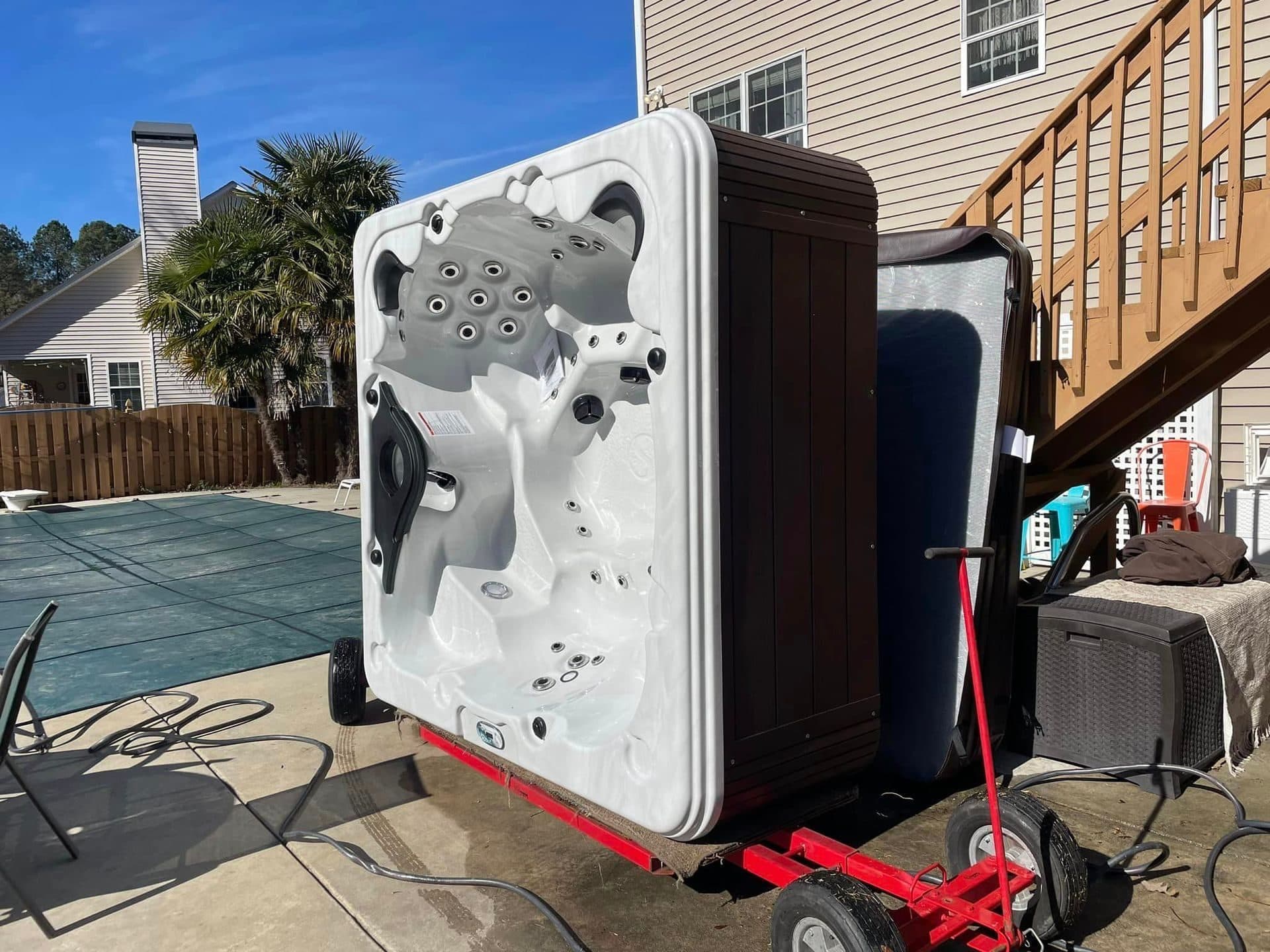 Crew padding a hot tub before the lift