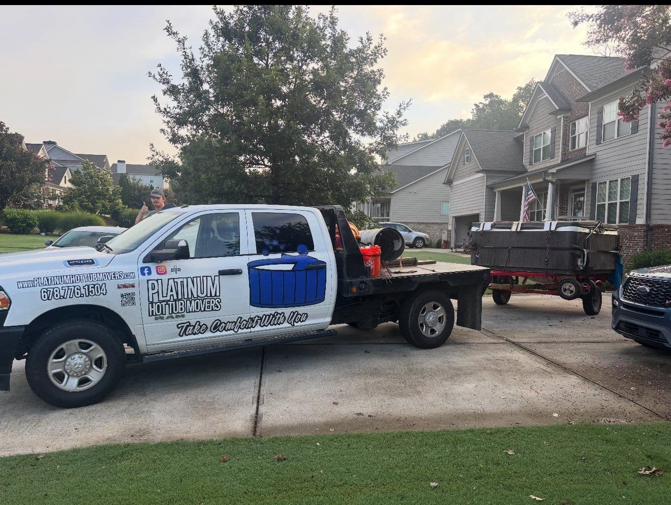 The branded Platinum Hot Tub Movers truck at golden hour with a tub on the trailer